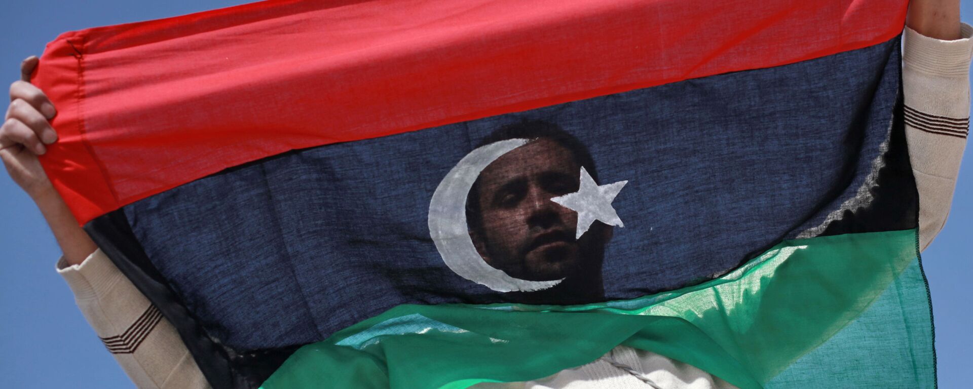 Un habitant de Benghazi avec un drapeau libyen - Sputnik Afrique, 1920, 13.11.2021