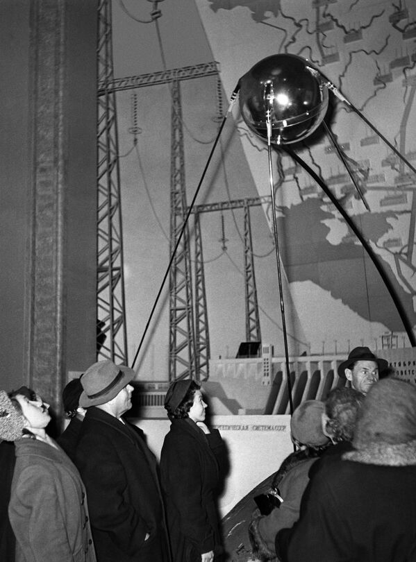 Le 4 octobre 1957, le premier satellite artificiel de la Terre Spoutnik-1 est lancé en URSS. Cet événement marque le début de l&#x27;ère spatiale dans l&#x27;histoire de l&#x27;humanité.Sur la photo: des visiteurs devant une réplique du premier satellite artificiel de la Terre dans le pavillon de la science de l’Exposition agricole de l&#x27;union (aujourd’hui Exposition des réalisations de l&#x27;économie nationale, VDNKh) à Moscou. - Sputnik Afrique