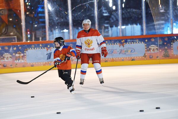 Vladimir Poutine lors d&#x27;une séance d&#x27;entraînement de hockey sur glace sur la patinoire du GOUM avec Dmitry Achtchepkov, 9 ans, originaire de la région de Tcheliabinsk et participant à la campagne Sapin de vœux, le 21 décembre 2020. - Sputnik Afrique