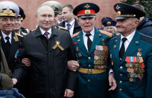 Poutine avec d’anciens combattants après avoir déposé des fleurs sur la tombe du Soldat inconnu dans le jardin Alexandre à l’occasion de la célébration du 76e anniversaire de la Victoire dans la Grande Guerre patriotique, le 9 mai 2021. - Sputnik Afrique