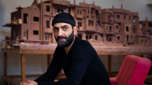 Сирийский скульптор Халед Давва работает над глиняным макетом разрушенной войной сирийской улицы - Sputnik Afrique