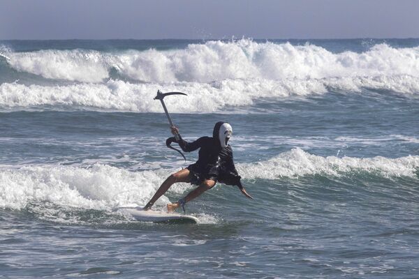 Un participant à une compétition de surf à l’occasion d’Halloween en République dominicaine. - Sputnik Afrique
