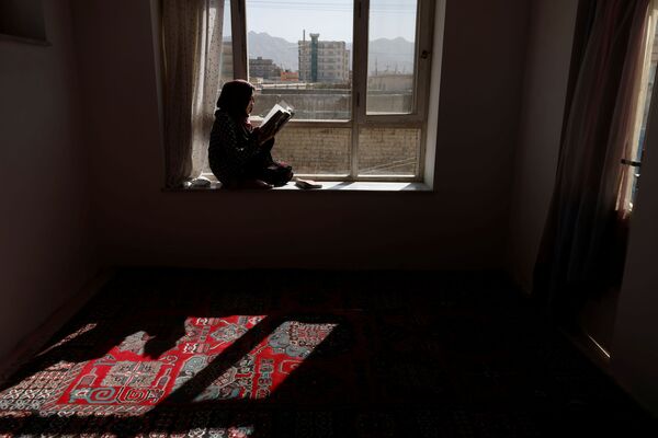 Hawa, 20 ans, lit un livre dans sa maison. Hawa a étudié la littérature russe à l&#x27;université Burhanuddin Rabbani, devenue l&#x27;université d&#x27;éducation de Kaboul après l&#x27;arrivée au pouvoir des talibans*, qui a fermé ses portes aux femmes. - Sputnik Afrique