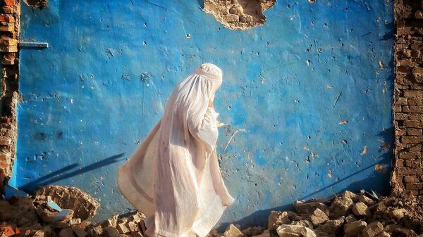 Девушка в белой бурке у разрушенного дома в Афганистане  - Sputnik Afrique