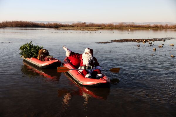 Le Père Noël avec des cadeaux sur un bateau gonflable sur la mer de Galilée en Israël. - Sputnik Afrique