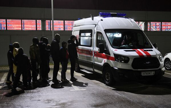 Des migrants du Moyen-Orient attendent un examen médical devant le centre logistique situé à la frontière entre la Biélorussie et la Pologne. - Sputnik Afrique