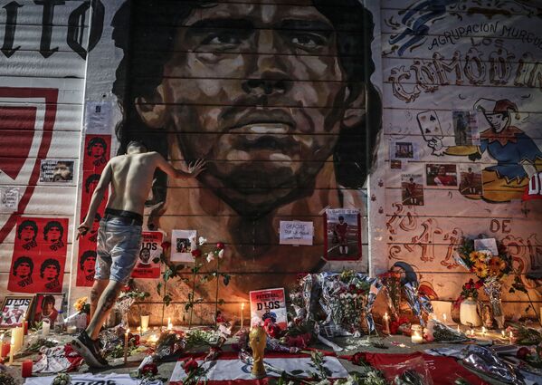Au cours de l’année qui a suivi la mort de Maradona, de nombreux lieux dédiés à sa mémoire sont apparus à Buenos Aires. On peut voir son image non seulement dans les stades, mais aussi sur les portes des magasins, sur les culées des ponts et dans les passages souterrains. Mais le club Argentinos Juniors, où Maradona a joué au début de sa carrière, est allé encore le plus loin: les fans ont installé dans une petite niche une sorte d’autel avec une image du footballeur. - Sputnik Afrique