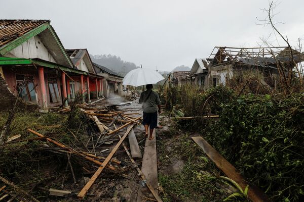 L’opération de sauvetage est entravée par la fumée toxique, le manque d’électricité et les pluies tropicales.Sur la photo: les conséquences de l’éruption du volcan Semeru dans le village de Curah Roboan, dans la province de Java orientale. - Sputnik Afrique