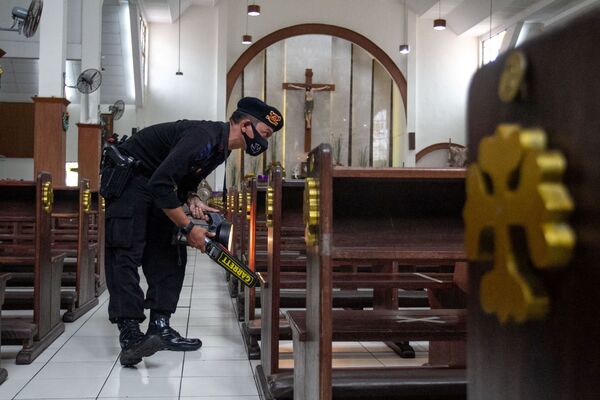 Sur la photo: un officier de police inspecte une église à Sleman, en Indonésie, avant la messe de Noël. - Sputnik Afrique