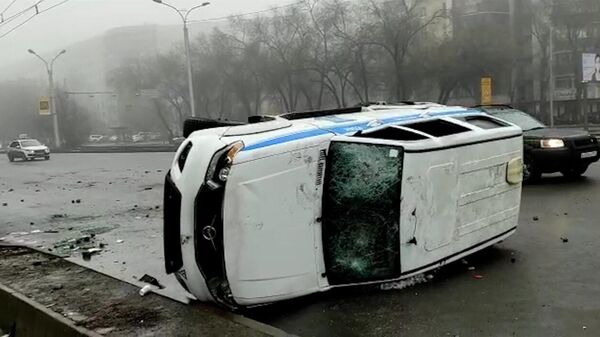 Une voiture de police renversée et endommagée par des manifestants à Almaty, janvier 2022 - Sputnik Afrique