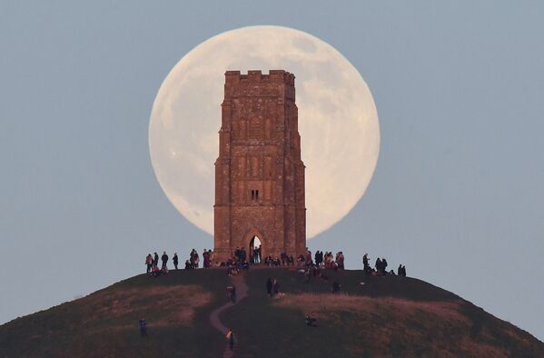La &quot;pleine lune du loup&quot; au-dessus de la tour Saint-Michel, sur la colline Glastonbury Tor, en Angleterre. - Sputnik Afrique