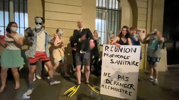 Une dizaine de personnes danse  en maillot de bain et masques de Blanquer, mimant son voyage à Ibiza devant le ministère de l’Éducation, le 19 janvier 2022 - Sputnik Afrique