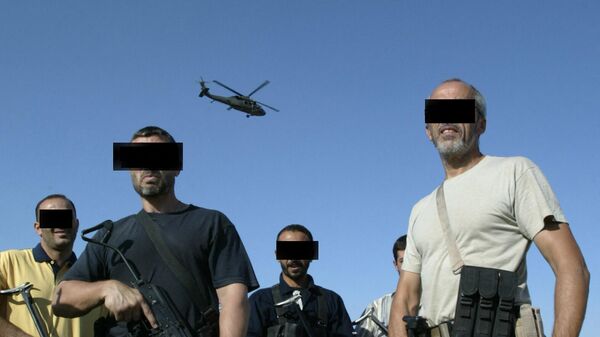 Des mercenaires irakiens et étrangers d'une société de sécurité privée se tiennent sur le toit d'une maison  - Sputnik Afrique