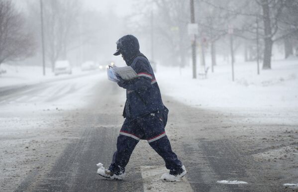 Une tempête de neige a frappé le Colorado.Sur la photo: un postier dans une rue de Denver pendant une tempête de neige. - Sputnik Afrique