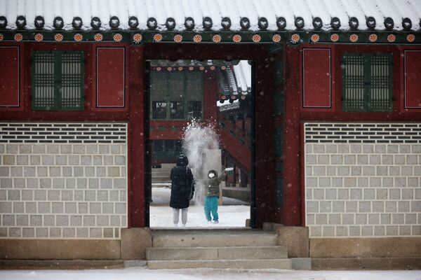 Un enfant se réjouit de la neige lors d&#x27;une visite au palais Deoksugung à Séoul, en Corée du Sud. - Sputnik Afrique