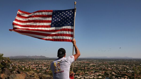Un homme tient un drapeau américain en Arizona - Sputnik Afrique