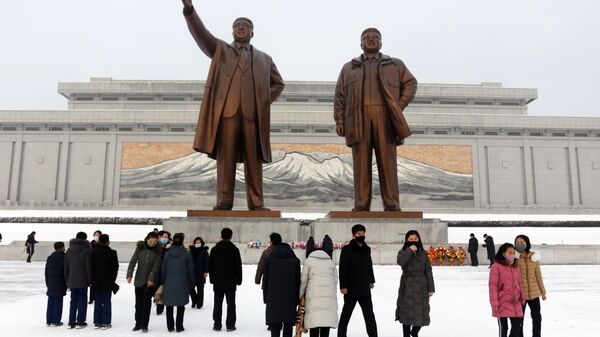 Люди пришли к статуям Ким Ир Сена и Ким Чен Ира во время празднования Нового года по лунному календарю в КНДР - Sputnik Afrique
