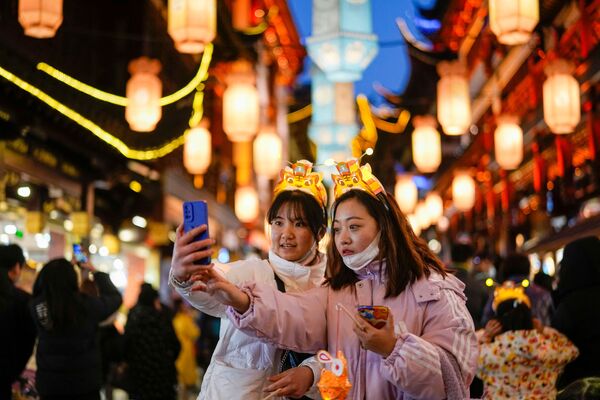 Ces trois dernières années, en raison de l’interdiction des événements de masse et d’autres restrictions liées à la pandémie, la fête des lanternes en Chine a été célébrée de manière plus modeste que d’habitude, mais les Chinois restent fidèles à leur ancienne tradition.Sur la photo: des jeunes femmes se prennent en photo pendant la fête des lanternes à Shanghai. - Sputnik Afrique