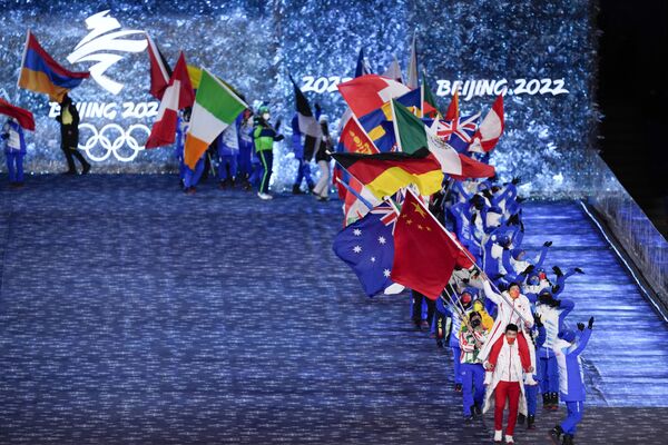 Porte-drapeaux avec les drapeaux des pays participants lors de la cérémonie de clôture des XXIVe Jeux olympiques d’hiver à Pékin. - Sputnik Afrique