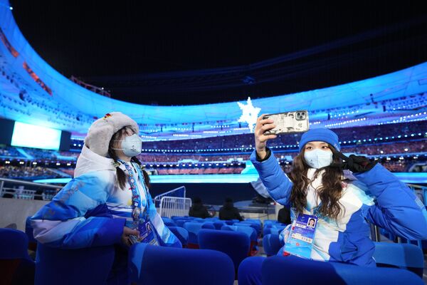 Des volontaires se prennent en photo avant la cérémonie de clôture des XXIVe Jeux olympiques d’hiver à Pékin. - Sputnik Afrique