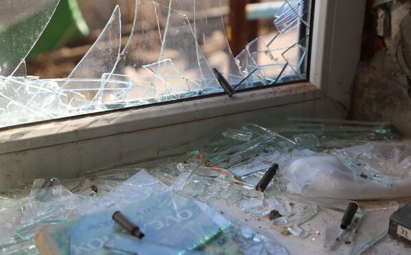 Un hôpital municipal et une sous-station électrique à Donetsk ont été bombardés par les forces de sécurité ukrainiennes. La façade et les fenêtres des écoles n°105 et n°56 de Donetsk ont été endommagées à la suite des bombardements par les forces armées ukrainiennes.Sur la photo: fenêtre brisée et obus sur le rebord de la fenêtre dans un immeuble à Donetsk. - Sputnik Afrique