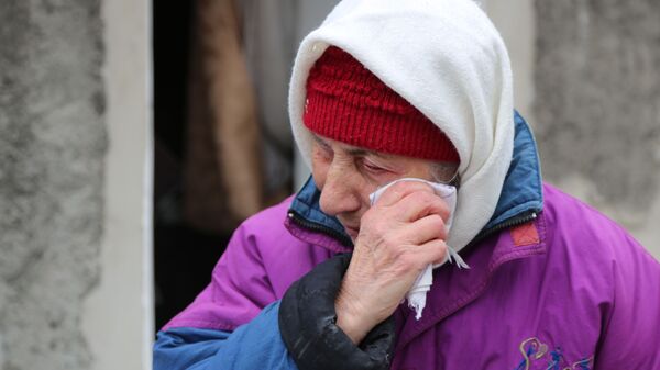 Пожилая женщина плачет около жилого дома в Киевском районе Донецка, разрушенном в результате обстрела - Sputnik Afrique