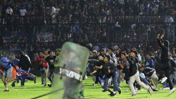 Soccer fans enter the pitch during a clash between supporters at Kanjuruhan Stadium in Malang, East Java, Indonesia - Sputnik Afrique