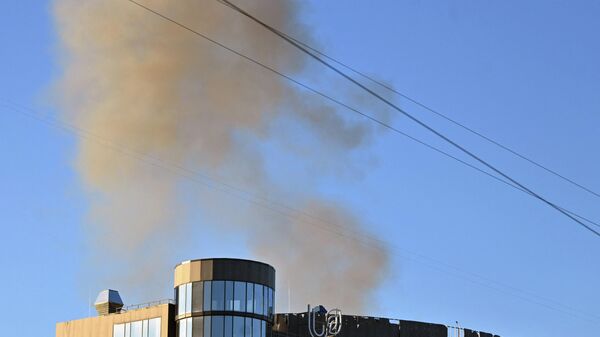 De la fumée s'élève derrière un bâtiment après une frappe à Kiev, le 17 octobre  - Sputnik Afrique