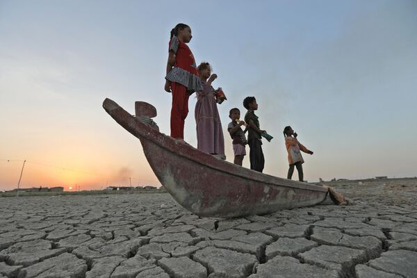 Une grave sécheresse a frappé l’Irak en juillet.  Sur la photo: des enfants sur un bateau à sec dans le marais de Chibayish, dans la province irakienne de Dhi Qar. - Sputnik Afrique