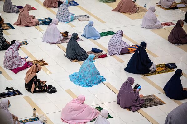 Des femmes musulmanes pratiquent la distanciation sociale, comme mesure préventive pour lutter contre la propagation du Covid-19, dans une mosquée de Putrajaya, en Malaisie, en 2021. - Sputnik Afrique