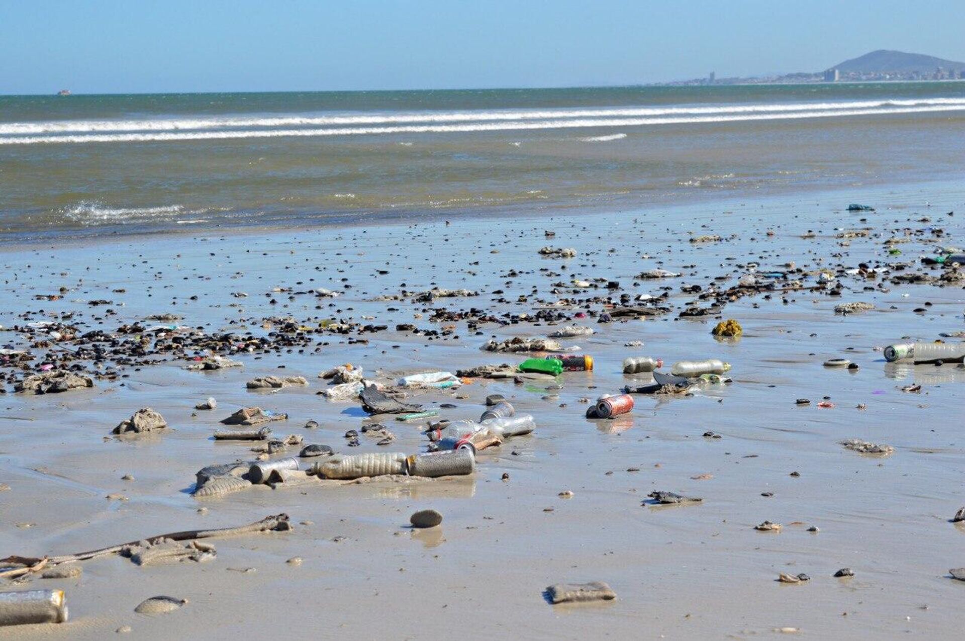 An ocean shore in South Africa littered with garbage, including plastic bottles and cans - Sputnik Africa, 1920, 30.03.2023