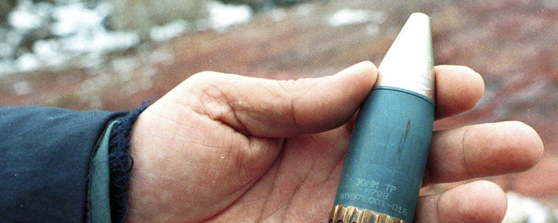 A member of a radiation team holds a 30mm armor-piercing shell containing depleted uranium, used by NATO during air strikes on Bosnia in 1995, which was found in a former military factory in the suburb of Vogosca, near Sarajevo, Jan. 15, 2001. - Sputnik Africa, 1920, 08.09.2023