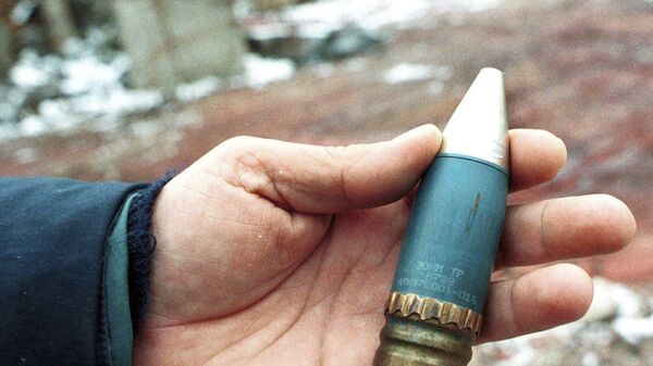 A member of a radiation team holds a 30mm armor-piercing shell containing depleted uranium, used by NATO during air strikes on Bosnia in 1995, which was found in a former military factory in the suburb of Vogosca, near Sarajevo, Jan. 15, 2001. - Sputnik Africa