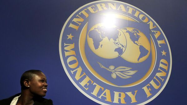 A woman sits in front of an International Monetary Fund logo at the venue of the IMF and World Bank meeting, Wednesday, Oct. 10, 2012. - Sputnik Africa