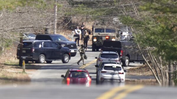Members of law enforcement assemble on a road, Thursday, April 13, 2023, in Dighton, Mass., near where FBI agents converged on the home of a Massachusetts Air National Guard member who has emerged as a main person of interest in the disclosure of highly classified military documents on the Ukraine. The guardsman was identified as 21-year-old Jack Teixeira. - Sputnik Africa