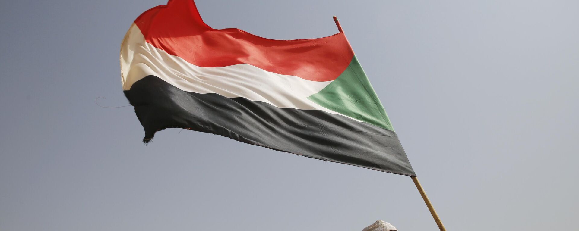 A Sudanese supporter of Gen. Mohammed Hamdan Dagalo, the deputy head of the military council, holds a national flag during a military-backed tribe's rally, in the East Nile province, Sudan, Saturday, June 22, 2019.  - Sputnik Africa, 1920, 05.03.2024