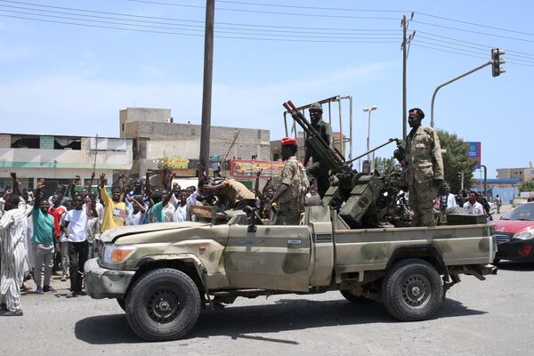 Sudanese greet army soldiers, loyal to army chief Abdel Fattah al-Burhan, in the Red Sea city of Port Sudan on April 16, 2023. - Sputnik Africa
