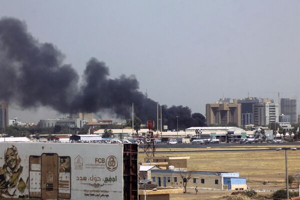 Heavy smoke billows above buildings in the vicinity of the Khartoum airport on April 15, 2023. - Sputnik Africa