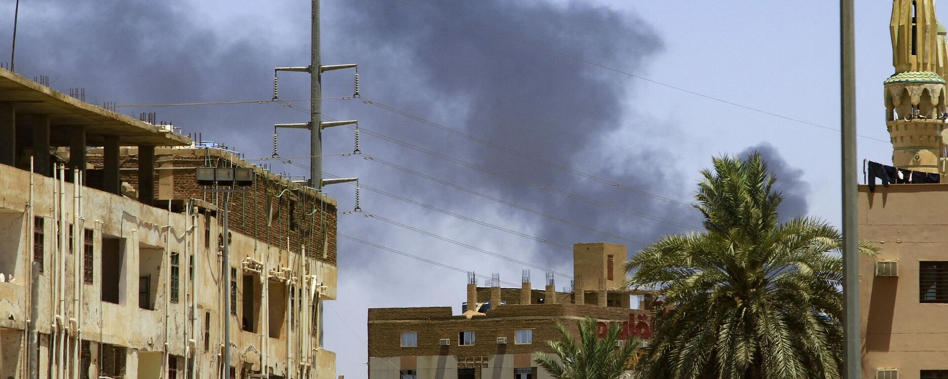 Smoke rises behind buildings in Khartoum on April 19, 2023, as fighting between the army and paramilitaries raged for a fifth day after a 24-hour truce collapsed - Sputnik Africa, 1920, 19.04.2023