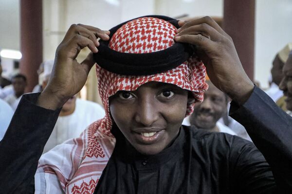 A Muslim worshipper adjusts his headdress after praying on the first day of Eid al-Fitr at al-Hara al-Rabaa Mosque in the Juraif Gharb neighbourhood of Khartoum. - Sputnik Africa