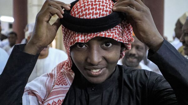 A muslim worshipper adjusts his headdress - Sputnik Africa