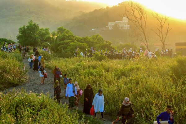 Muslims arrive to participate in morning prayers celebrating Eid al-Fitr at the Parangkusumo sand dunes in Bantul.  - Sputnik Africa