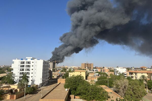 A column of smoke rises behind buildings near the airport area in Khartoum on April 19, 2023, amid fighting between the army and paramilitaries following the collapse of a 24-hour truce.  - Sputnik Africa