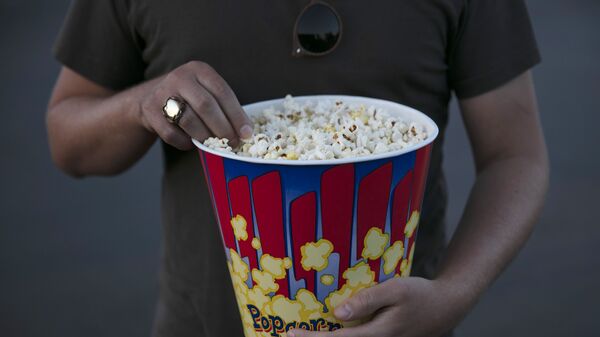 A moviegoer eats popcorn at Mission Tiki drive-in theater in Montclair, Calif., Thursday, May 28, 2020. - Sputnik Africa
