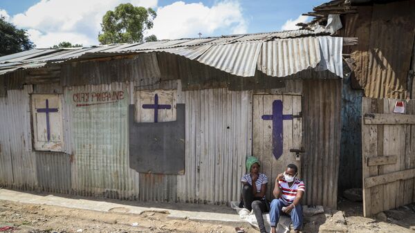 In this Sunday, April 12, 2020 file photo, two residents sit outside a closed church, after religious public services were stopped to limit the spread of the coronavirus, in the Mathare slum, or informal settlement, of Nairobi, Kenya.  - Sputnik Africa