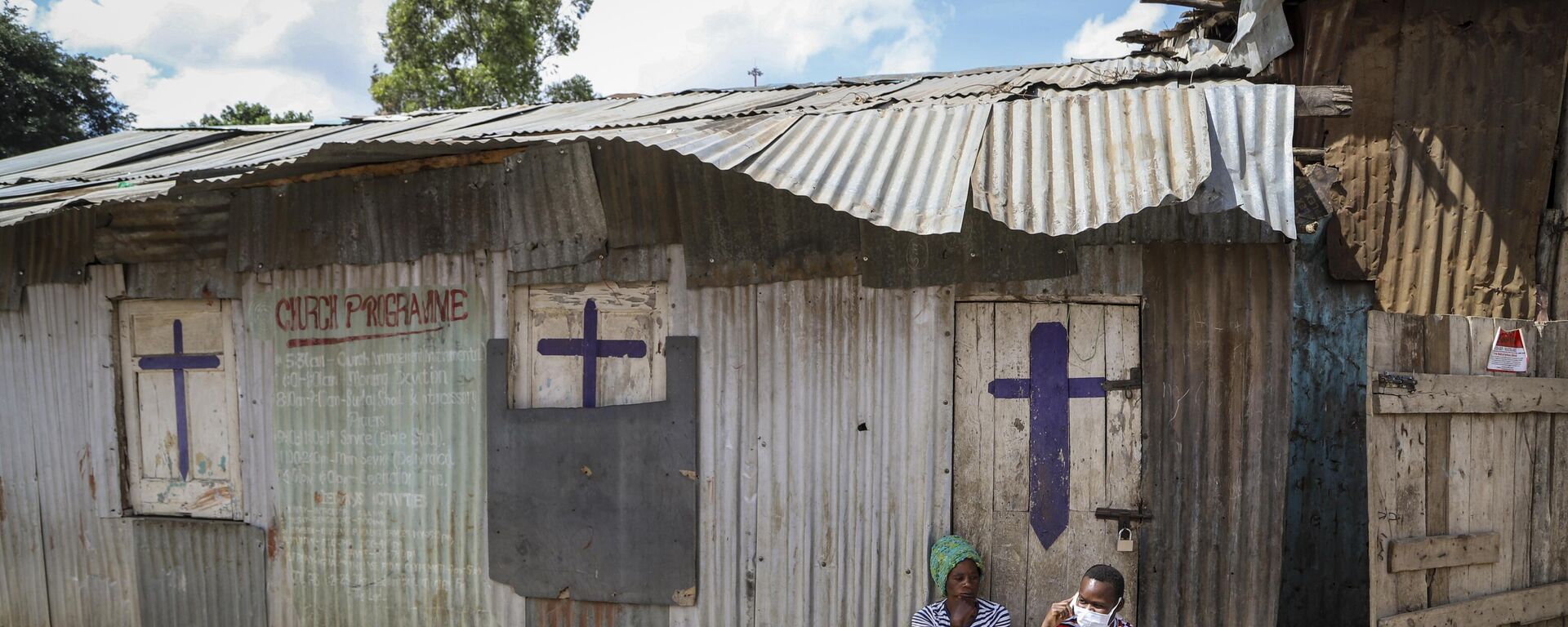 In this Sunday, April 12, 2020 file photo, two residents sit outside a closed church, after religious public services were stopped to limit the spread of the coronavirus, in the Mathare slum, or informal settlement, of Nairobi, Kenya.  - Sputnik Africa, 1920, 22.04.2023