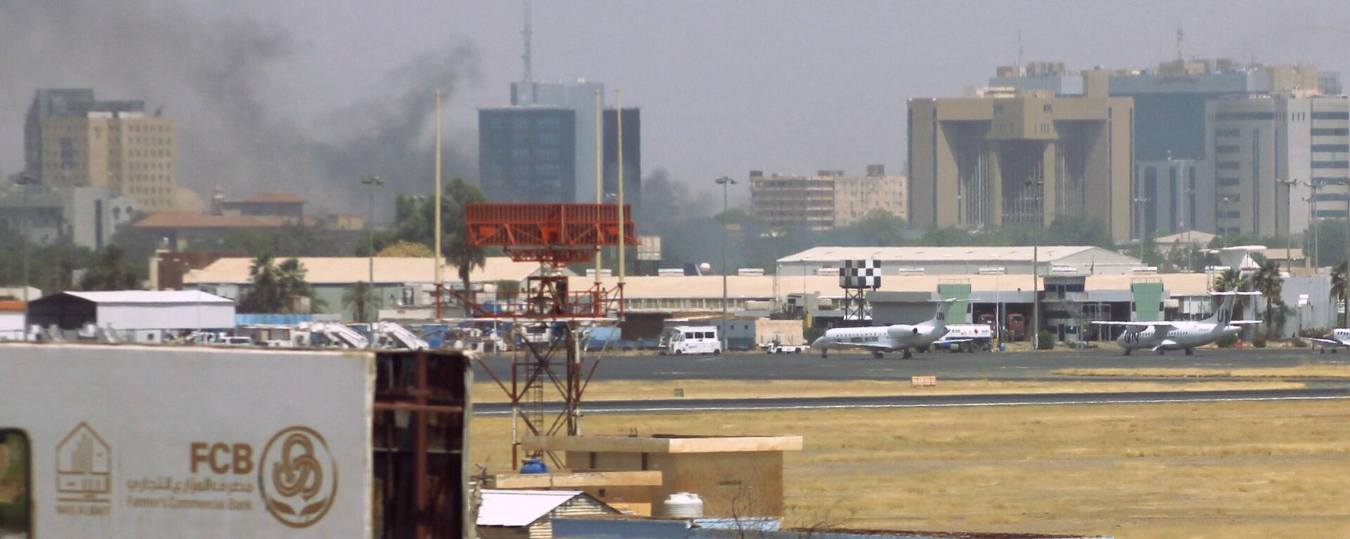 Military vehicles can be seen as smoke billows above buildings in the vicinity of the Khartoum airport on April 15, 2023, amid clashes in the city. - Sputnik Africa, 1920, 23.04.2023