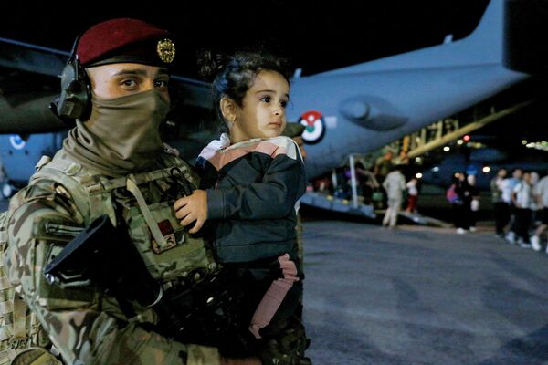 A soldier carries a child as people evacuated from Sudan disembark from an aircraft at a military airport in Amman on April 24, 2023. Foreign countries rushed to evacuate their nationals from Sudan as deadly fighting between forces loyal to two rival generals entered its second week. - Sputnik Africa