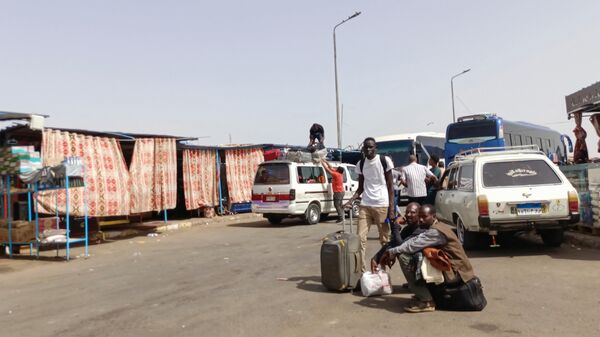 Passengers fleeing war-torn Sudan disembark at the Wadi Karkar bus station near the Egyptian city of Aswan, on April 25, 2023 - Sputnik Africa