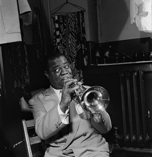 American jazzman Louis Armstrong plays trumpet in his dressing room before a show in 1947 in a New York jazz cabaret.  - Sputnik Africa